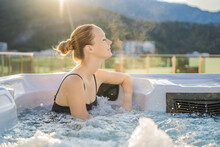Portrait Of Young Carefree Happy Smiling Woman Relaxing At Hot Tub During Enjoying Happy Traveling Moment Vacation Life Against The Background Of Green Big Mountains