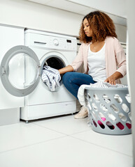 Canvas Print - She doesnt mind spending her day doing chores. Shot of a young attractive woman doing laundry at home.