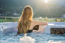 Portrait Of Young Carefree Happy Smiling Woman Relaxing At Hot Tub During Enjoying Happy Traveling Moment Vacation Life Against The Background Of Green Big Mountains