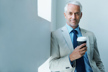 Wall Mural - Time for business. Portrait of a mature businessman drinking a take-away cup of coffee.