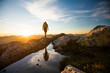 © Cavan Images - reflected view of backpacker hiking on mountain rige.