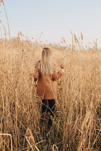Back Of Woman In Dry Autumn Grass Field