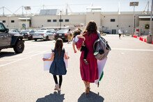 Mother & Two Daughters Walking Onto Base For Military Homecoming