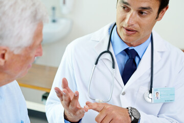 Canvas Print - Making sure his patient understands.... Shot of a handsome young doctor explaining the situation to a senior patient.