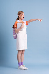 Wall Mural - Young Asian student posing on blue background