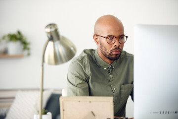 Hes focused on working his way to the top. Cropped shot of a young businessman sitting behind a computer in his office.