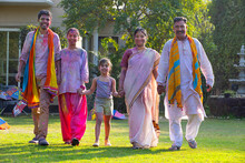 Indian Family Celebrating Holi Together In The Garden