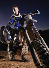 Hes The Poster Boy For Dirtbiking. Portrait Of A Young Motocross Rider Posing On His Bike.