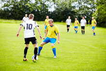 Playing Good Defense. A Group Of Soccer Players In The Middle Of A Game.
