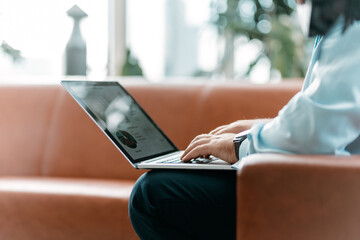 Wall Mural - business man is working on a laptop sitting in the office lobby.