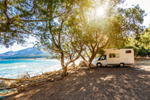 Motorhome RV Parked On The Beach Under A Tree Facing The Sea, Crete, Greece.