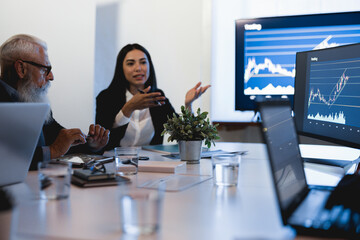 Business trader people talking about new trading strategies inside bank meeting room - Focus on senior man hands