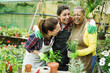 © DisobeyArt - Multiracial women working inside greenhouse garden with aromatic herbs plants - Nursery and spring concept - Main focus on center female face