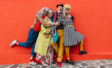 Four happy senior citizens having fun in colourful clothing