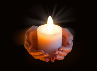 Wall Mural - Women's hands holding a candle