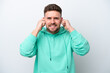 © luismolinero - Young caucasian man isolated on white background frustrated and covering ears