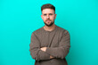 © luismolinero - Young caucasian man isolated on blue background with unhappy expression