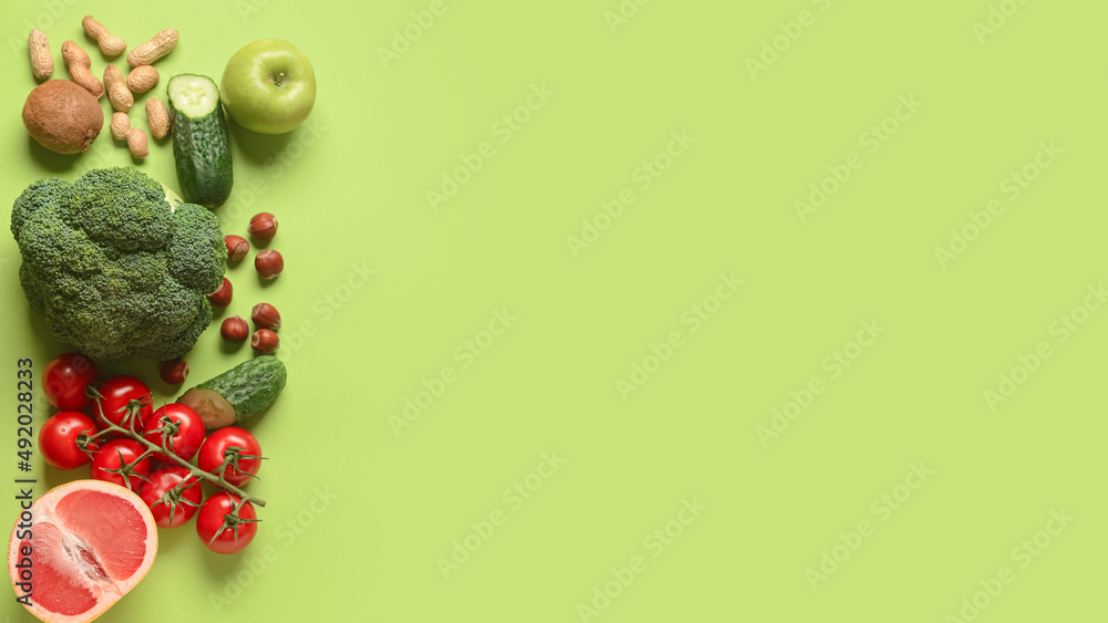 Different vegetables, fruits and nuts on green background