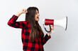 © luismolinero - Teenager Brazilian girl isolated on white background shouting through a megaphone to announce something in lateral position