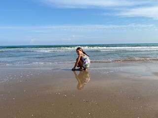 Wall Mural - child playing on the beach, winter sun, Spain, Half term, reflection