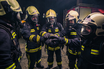 Wall Mural - Team of firemen in uniform with gas masks inside the fire department