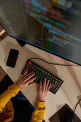 IT developer typing code on computer at home