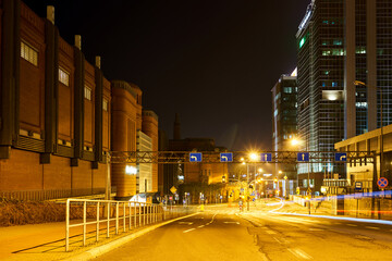 Wall Mural - Street with historic buildings and modern office buildings during the night in the city of Poznan