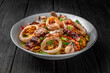 © Екатерина - Soba, udon, asian wheat noodles with seafood: shrimps, mussels, squid and vegetables: broccoli, carrots, sweet peppers, zucchini on a black background. Asian style. Japanese food