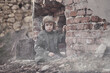 © Jacek - War and the child. Little scared boy in the ruins of the house.