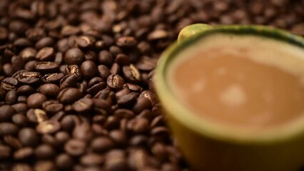 Wall Mural - Close up of coffee cup.coffee beans.Falling drop into coffee cup,rotate coffee beans cups.pour the milk into the glass coffee