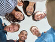 © Tabitha R/peopleimages.com - Part of a motivated team. Low angle shot of a team of people smiling down at the camera positively.
