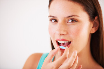 Wall Mural - Starting the day with a vitamin capsule. Portrait of a beautfiul young woman about to take a tablet.