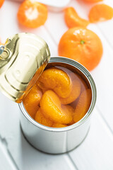 Poster - Canned tangerine. Pickled mandarin fruit in can on white table.