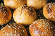 homemade fragrant burger buns sprinkled with sesame seeds are baked in the oven. background for fast food advertising, a special offer for starting a business. selective focus