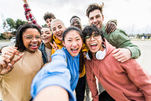 Multiracial Friends Taking Big Group Selfie Shot Smiling At Camera -Laughing Young People Standing Outdoor And Having Fun - Cheerful Students Portrait Outside School - Human Resources Concept..