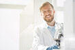 © yurolaitsalbert - smiling scientist sitting at a laboratory table.