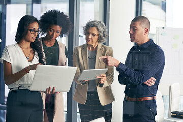 Wall Mural - guiding their company to the best future possible. shot of a team of colleagues using modern technol