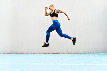 Poster - We have lift off. Full length shot of an attractive young female athlete running along the track.