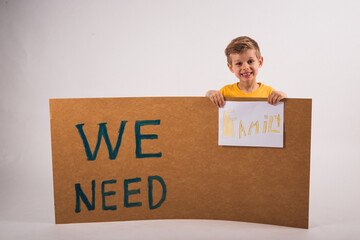 Charming little boyl in yellow t-shirts is holding a tablet 