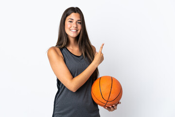 Wall Mural - Young brazilian woman playing basketball isolated on white background pointing to the side to present a product