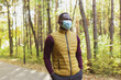 © satura_ - Handsome african american man wearing casual clothes and medical mask smiling happy walking in spring park - copy space
