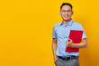 © Bangun Stock Photo - Portrait of handsome smiling young man in glasses holding document folder isolated on yellow background