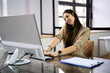 © Andrey Popov - Young Businesswoman On Call While Using Computer At Desk