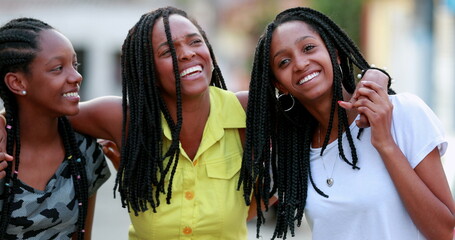 Wall Mural - Funny mother hugging daughters outside. African black ethnicity family love and affection