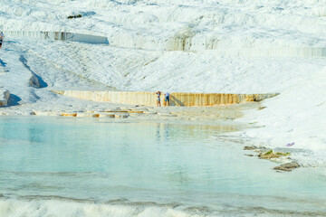 Wall Mural - Natural travertine pools and terraces in Pamukkale. Cotton castle in southwestern Turkey. Tourists walking and bathing in Natural travertine pools