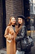 © hetmanstock2 - Two female friends in fashion clothes standing on the street