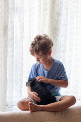 Wall Mural - A boy with a little dog playing at home.