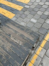 Weathered Square Paving Stones With Yellow Painted Lines And Worn Wooden Ramp Abstract Urban Vertical Background Pattern
