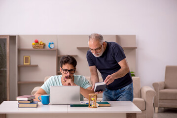 Young male student and his grandfather at home