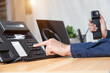 © A Stockphoto - Call center staff man hand point to press the button number on the phone office desk , Communication support, call center and customer service help desk. for (call center) concept